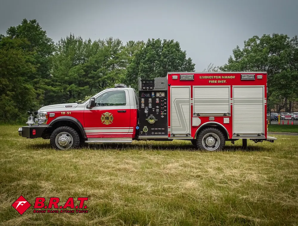 Exterior view of small fire truck showing cab, body compartments, and wheel/tire area.