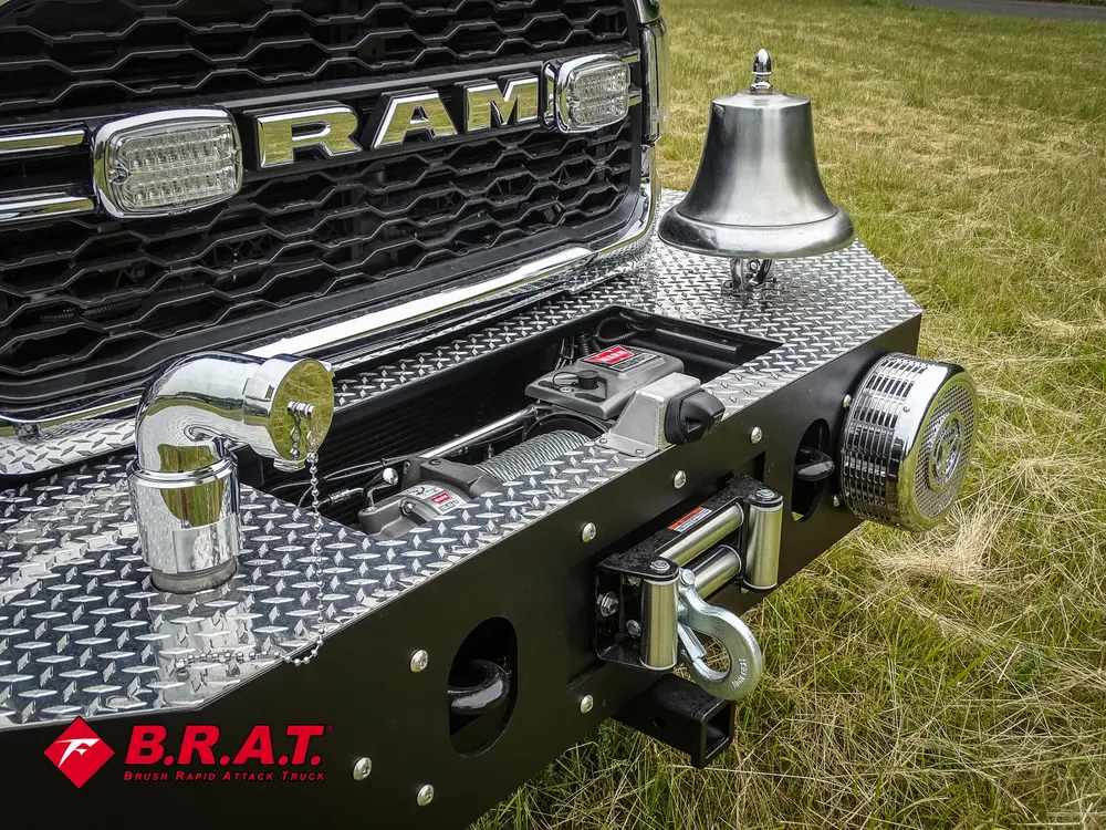 Exterior view of small fire truck showing cab, body compartments, and wheel/tire area.