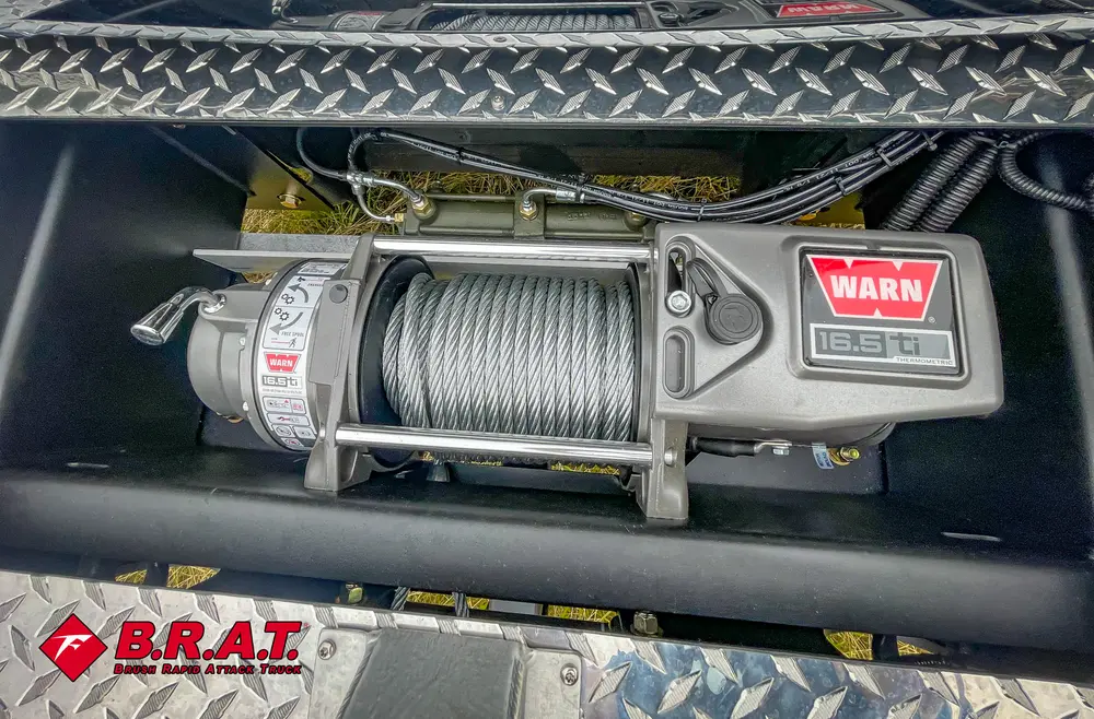 Exterior view of small fire truck showing cab, body compartments, and wheel/tire area.