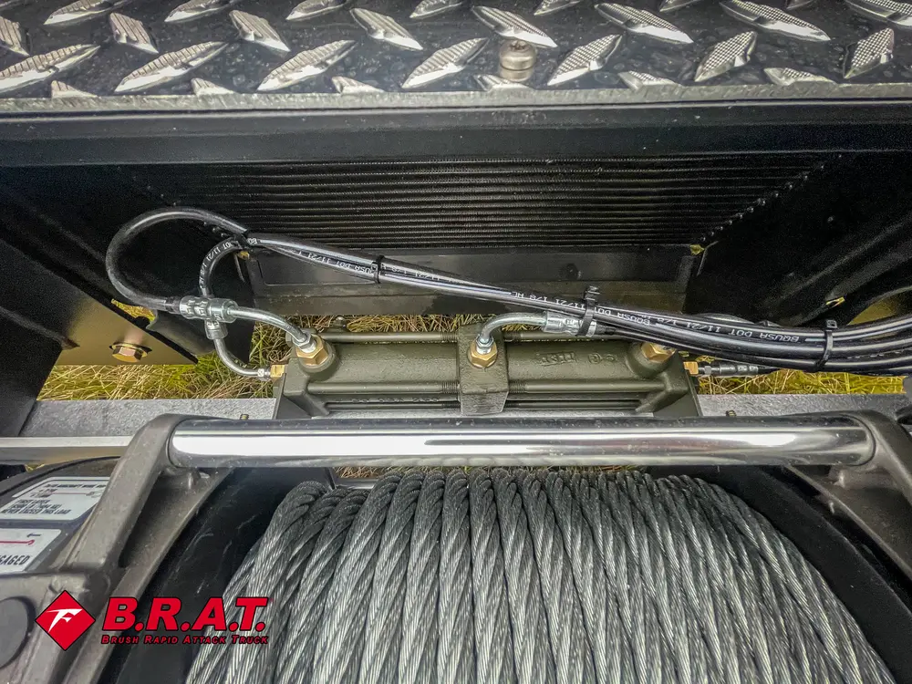 Exterior view of small fire truck showing cab, body compartments, and wheel/tire area.