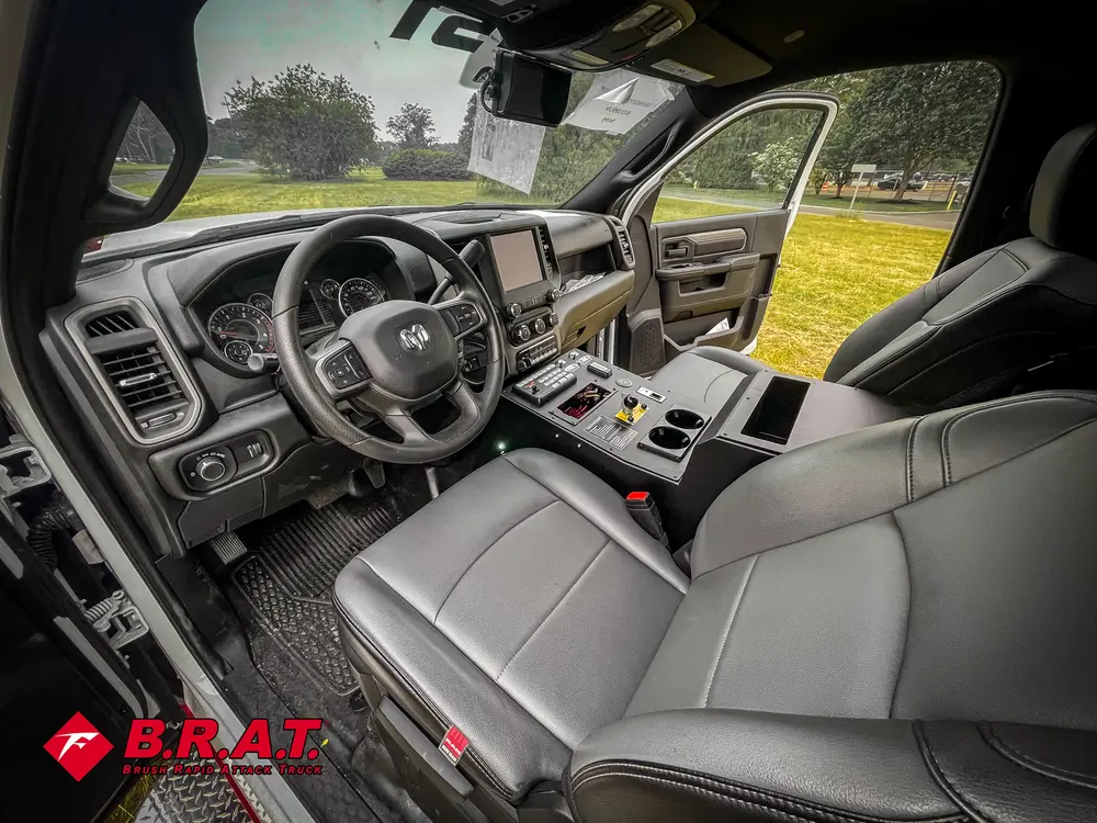 Exterior view of small fire truck showing cab, body compartments, and wheel/tire area.
