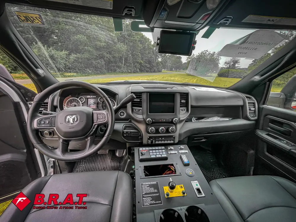 Exterior view of small fire truck showing cab, body compartments, and wheel/tire area.