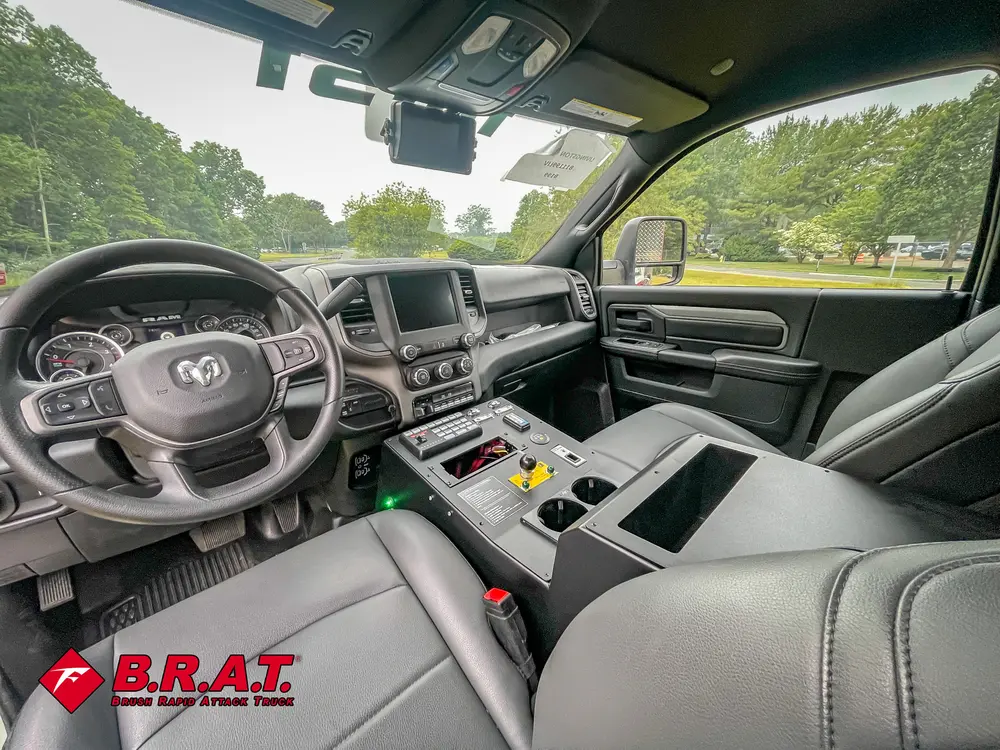 Exterior view of small fire truck showing cab, body compartments, and wheel/tire area.