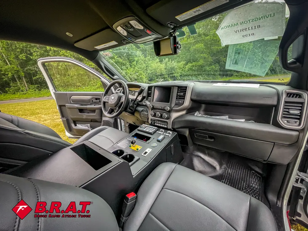 Exterior view of small fire truck showing cab, body compartments, and wheel/tire area.