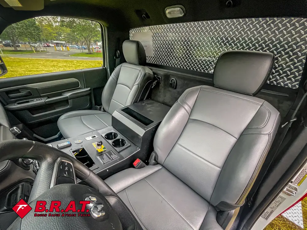 Exterior view of small fire truck showing cab, body compartments, and wheel/tire area.