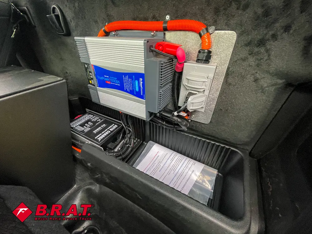 Exterior view of small fire truck showing cab, body compartments, and wheel/tire area.