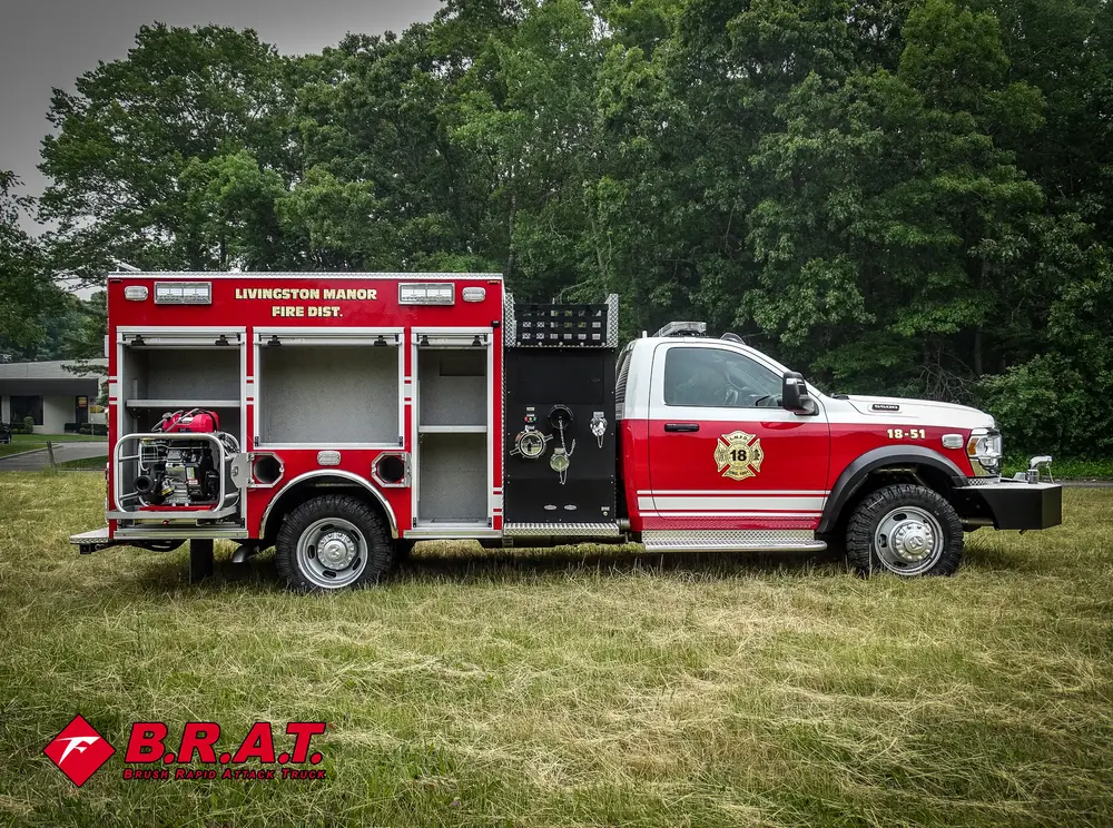 Exterior view of small fire truck showing cab, body compartments, and wheel/tire area.