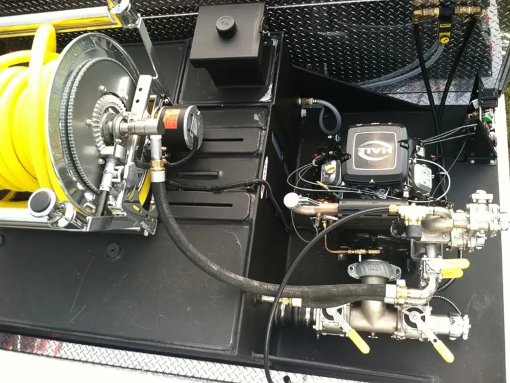 Exterior view of small fire truck showing cab, body compartments, and wheel/tire area.