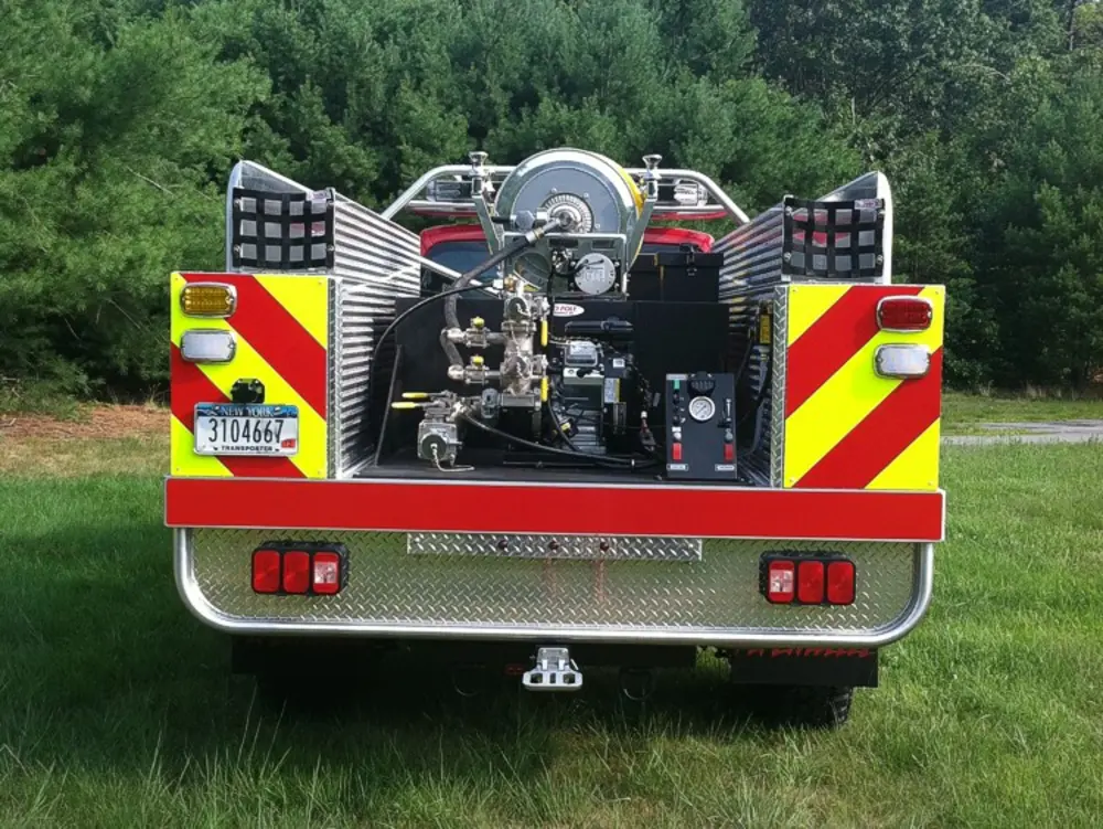 Exterior view of small fire truck showing cab, body compartments, and wheel/tire area.