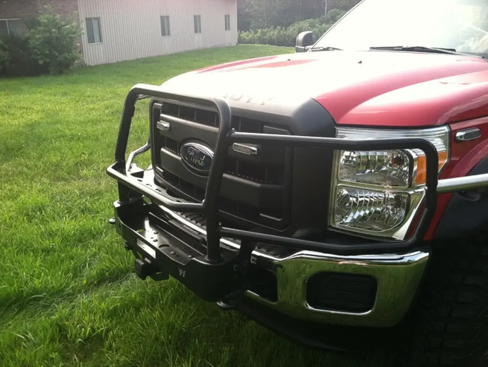 Exterior view of small fire truck showing cab, body compartments, and wheel/tire area.