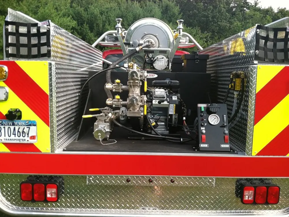 Exterior view of small fire truck showing cab, body compartments, and wheel/tire area.