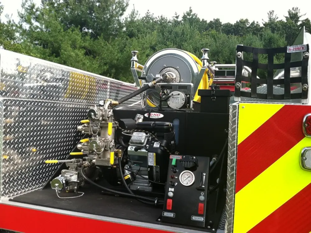 Exterior view of small fire truck showing cab, body compartments, and wheel/tire area.