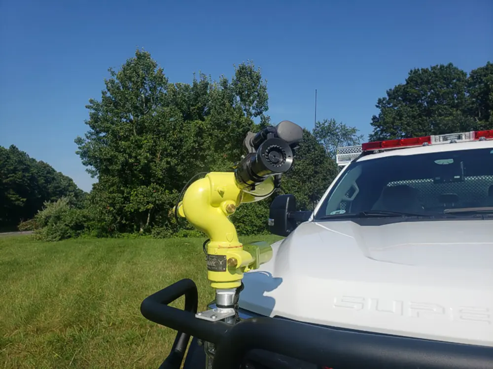 Exterior view of small fire truck showing cab, body compartments, and wheel/tire area.