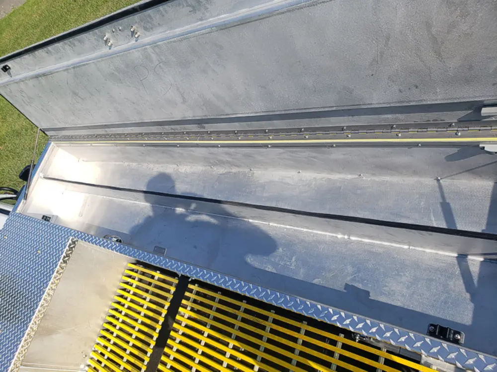 Exterior view of small fire truck showing cab, body compartments, and wheel/tire area.