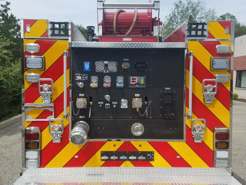 Exterior view of small fire truck showing cab, body compartments, and wheel/tire area.