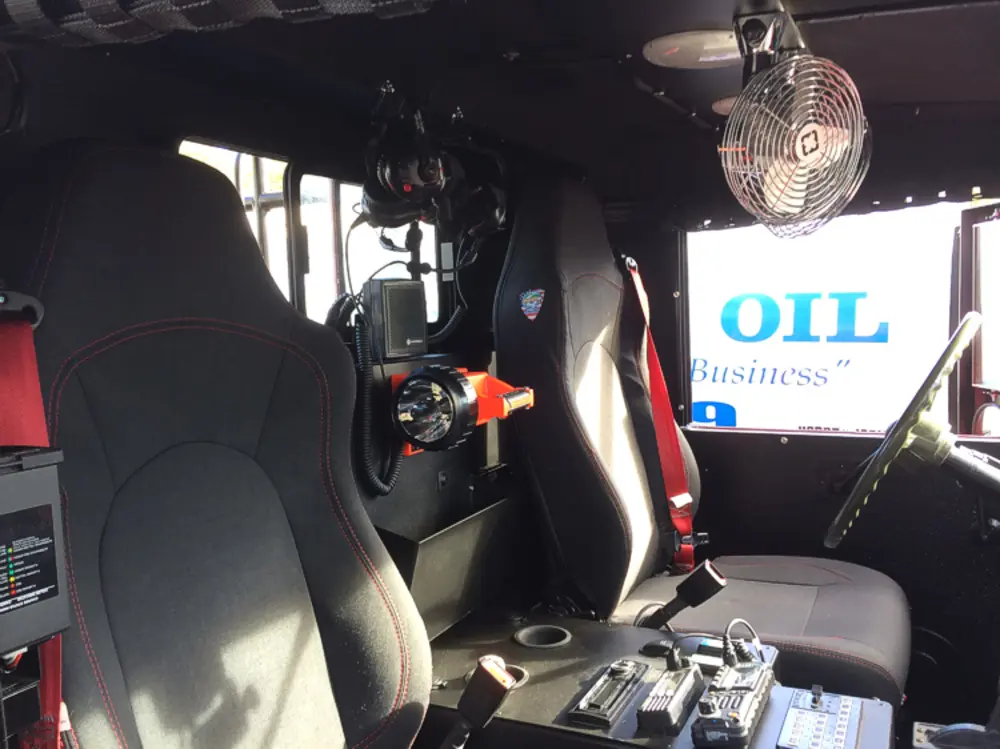 Exterior view of small fire truck showing cab, body compartments, and wheel/tire area.