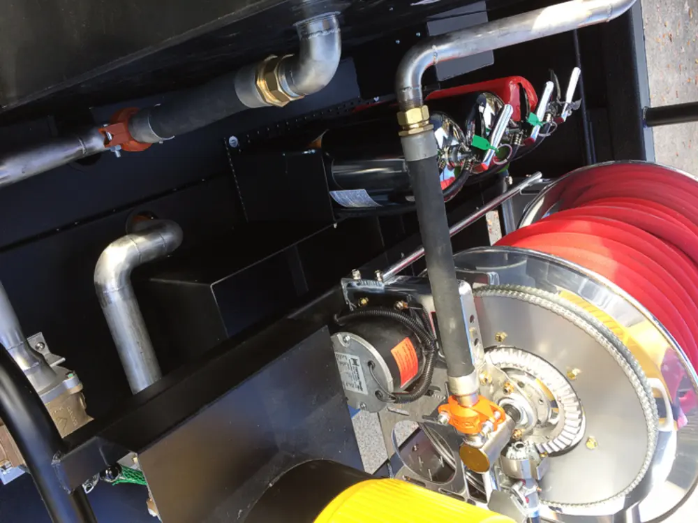 Exterior view of small fire truck showing cab, body compartments, and wheel/tire area.