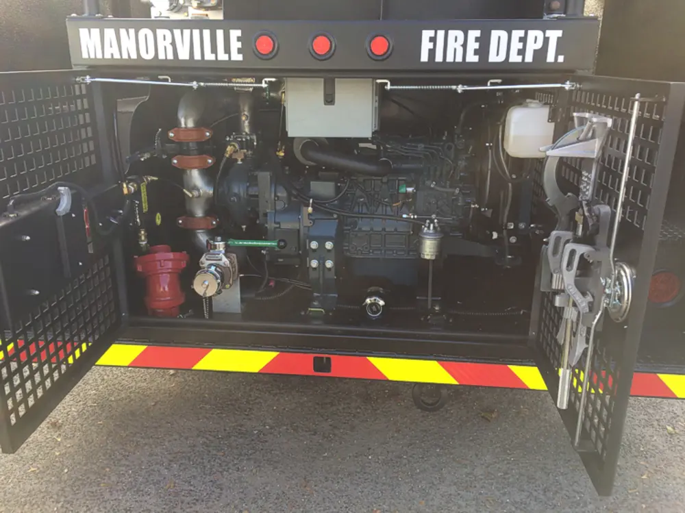 Exterior view of small fire truck showing cab, body compartments, and wheel/tire area.