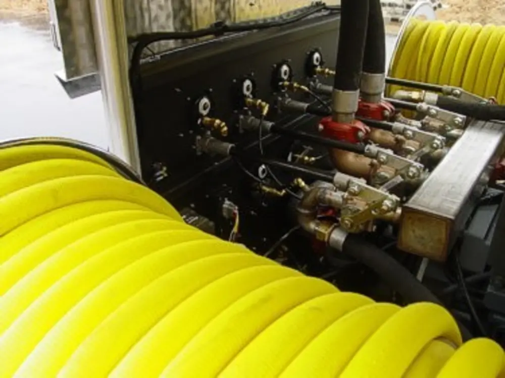 Exterior view of small fire truck showing cab, body compartments, and wheel/tire area.