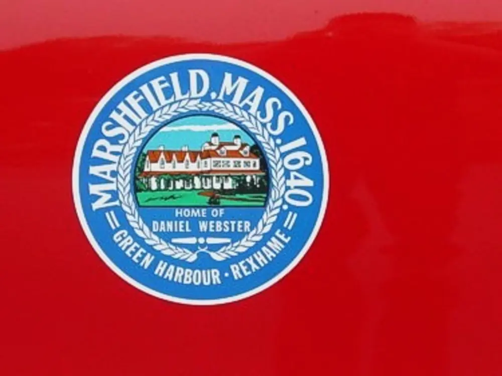 Exterior view of small fire truck showing cab, body compartments, and wheel/tire area.