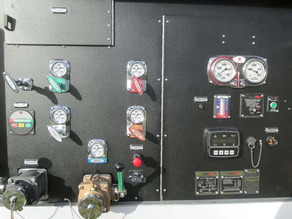 Exterior view of small fire truck showing cab, body compartments, and wheel/tire area.