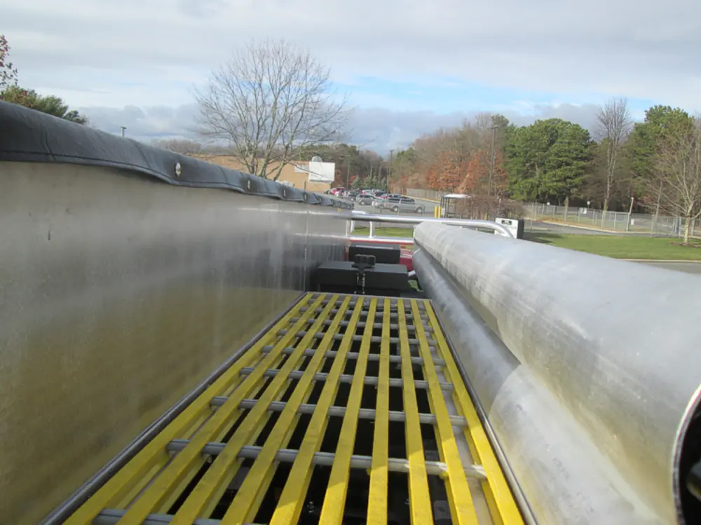 Exterior view of small fire truck showing cab, body compartments, and wheel/tire area.