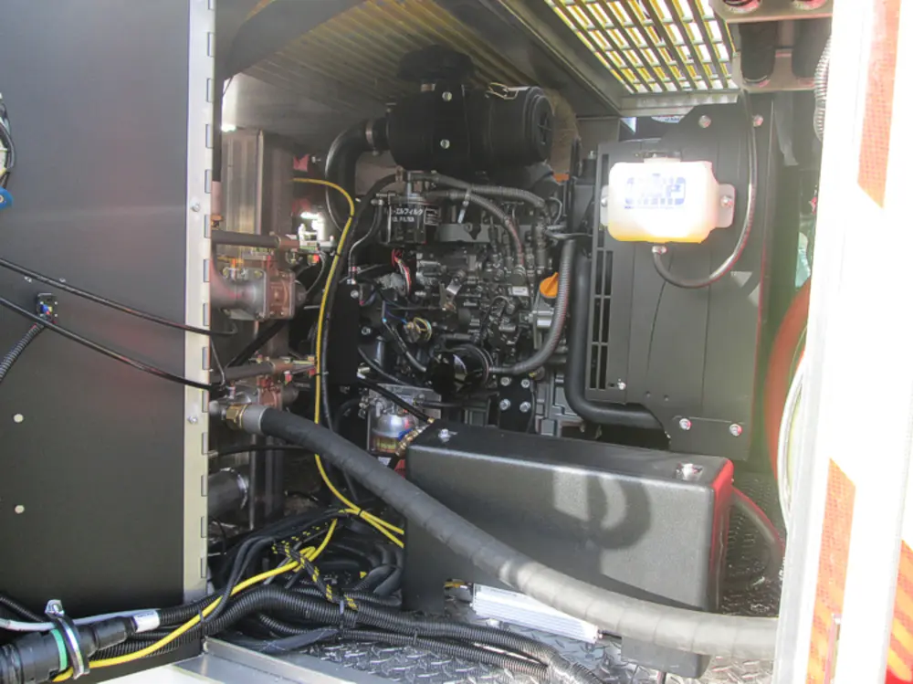 Exterior view of small fire truck showing cab, body compartments, and wheel/tire area.