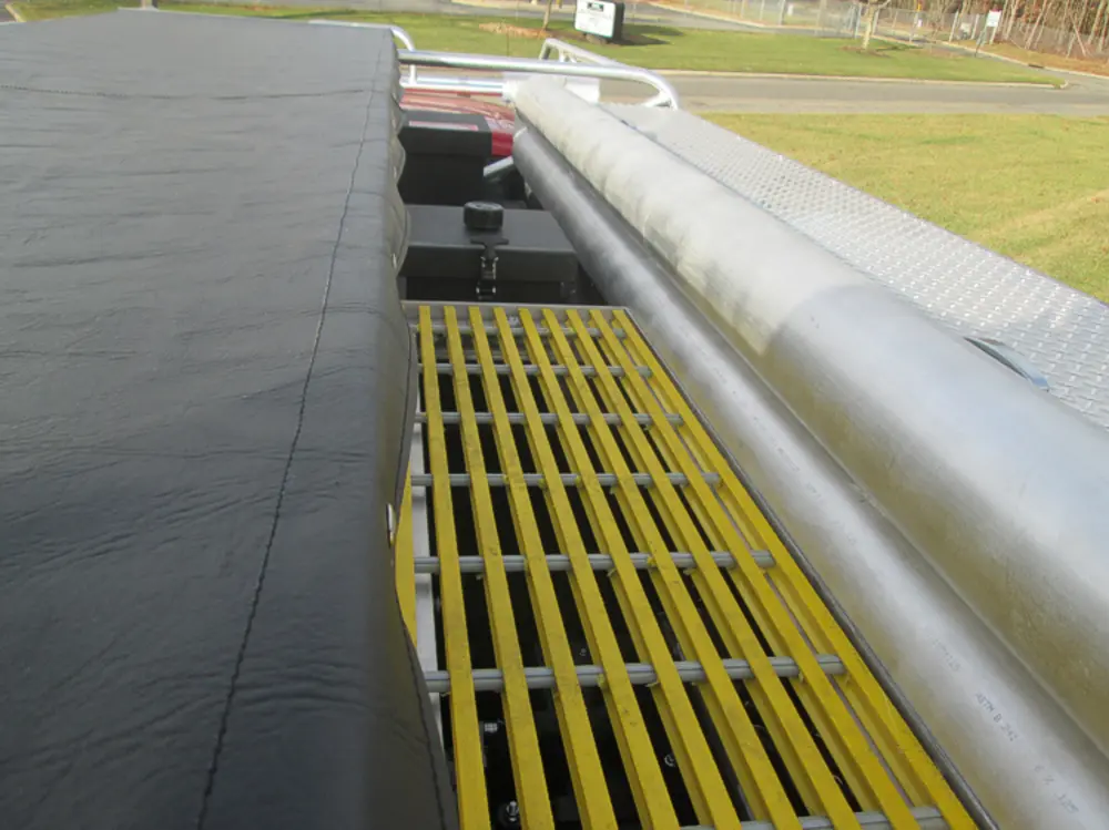 Exterior view of small fire truck showing cab, body compartments, and wheel/tire area.