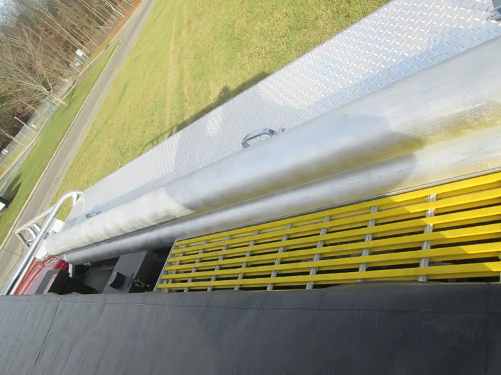 Exterior view of small fire truck showing cab, body compartments, and wheel/tire area.
