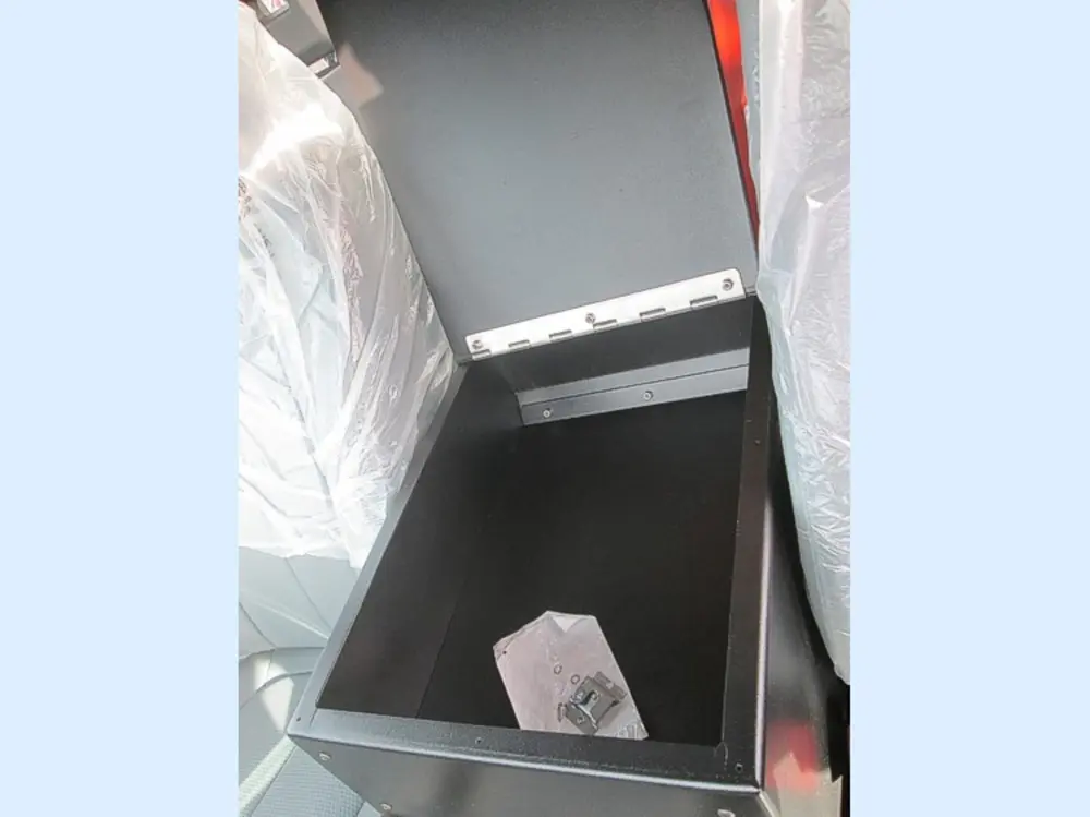 Exterior view of small fire truck showing cab, body compartments, and wheel/tire area.