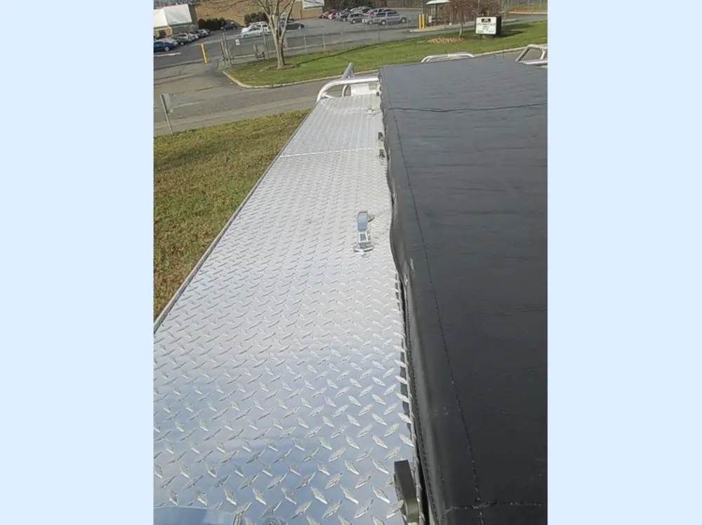 Exterior view of small fire truck showing cab, body compartments, and wheel/tire area.