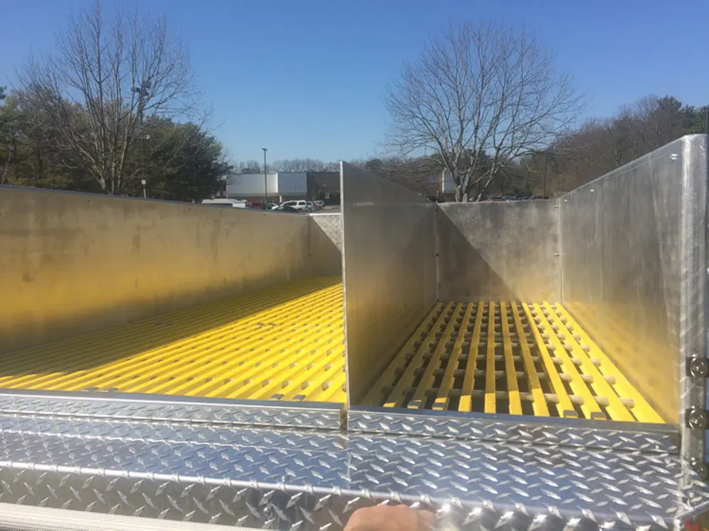 Exterior view of small fire truck showing cab, body compartments, and wheel/tire area.