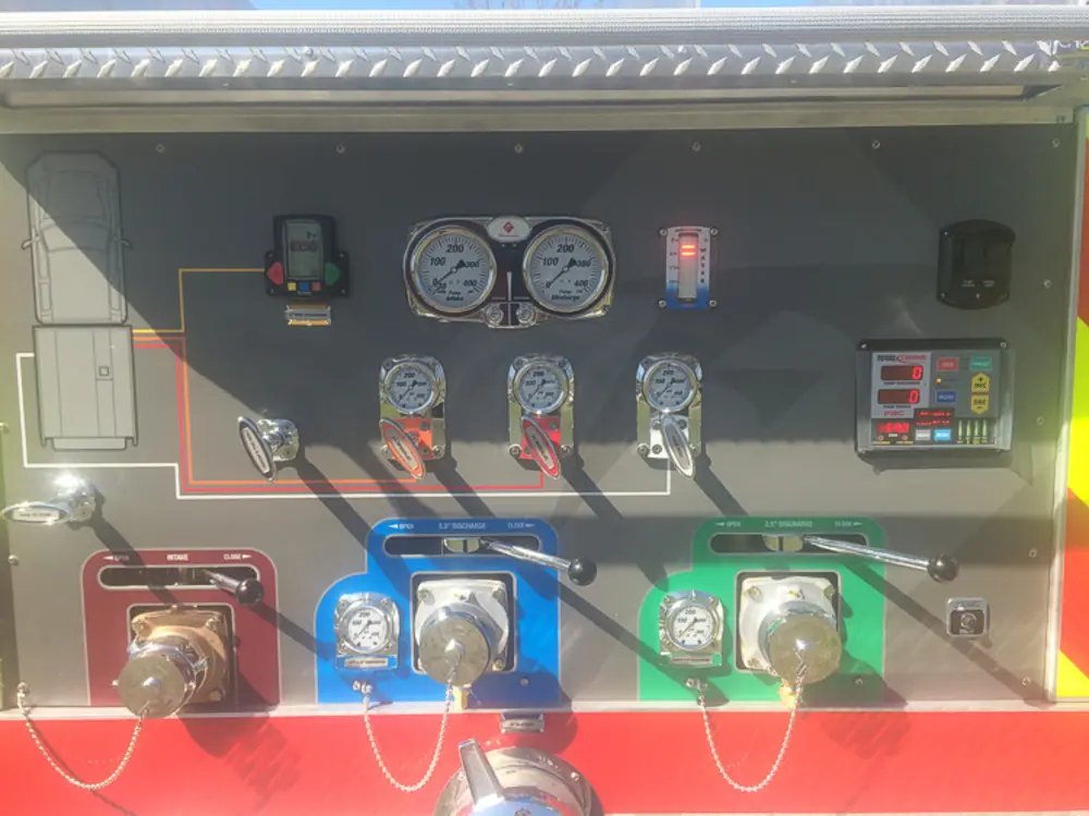 Exterior view of small fire truck showing cab, body compartments, and wheel/tire area.