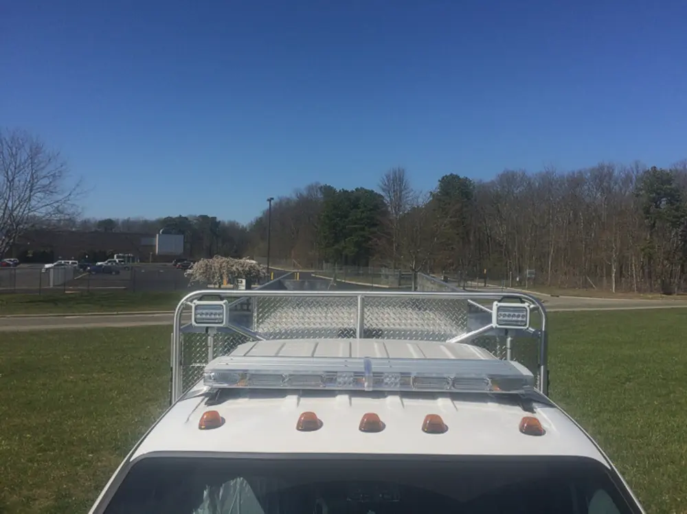 Exterior view of small fire truck showing cab, body compartments, and wheel/tire area.