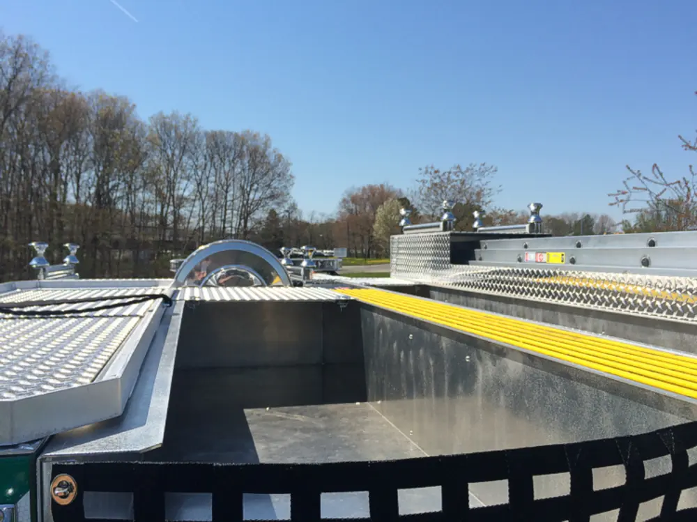 Exterior view of small fire truck showing cab, body compartments, and wheel/tire area.