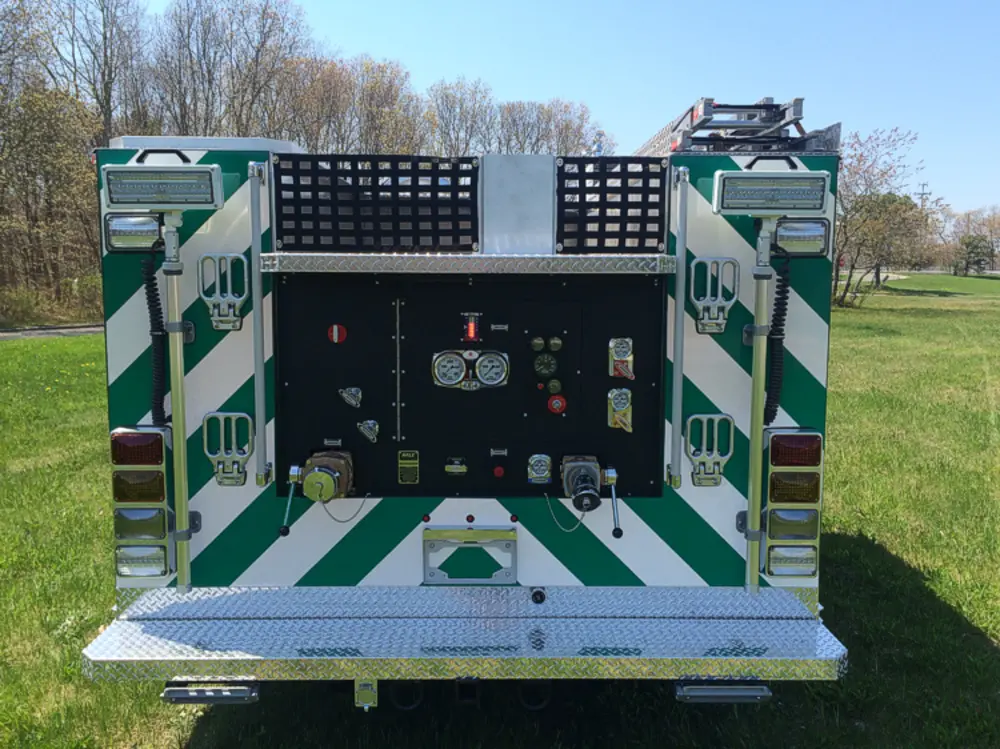 Exterior view of small fire truck showing cab, body compartments, and wheel/tire area.