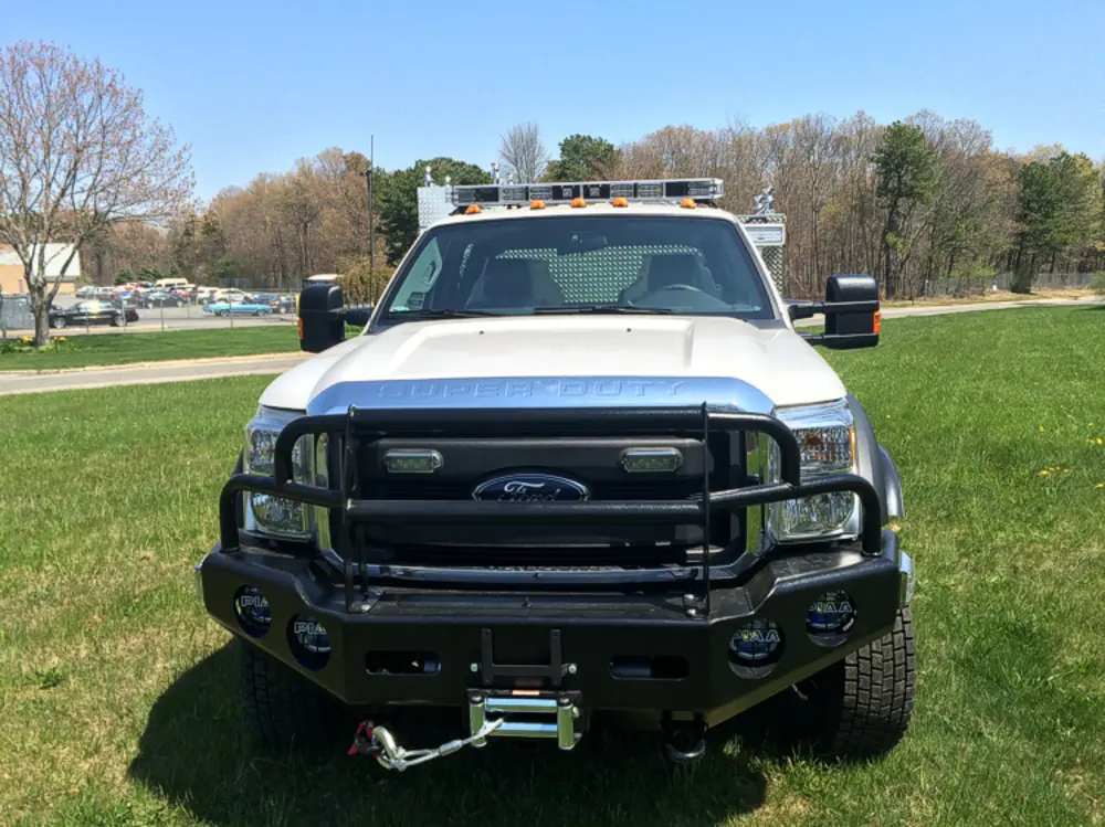 Exterior view of small fire truck showing cab, body compartments, and wheel/tire area.