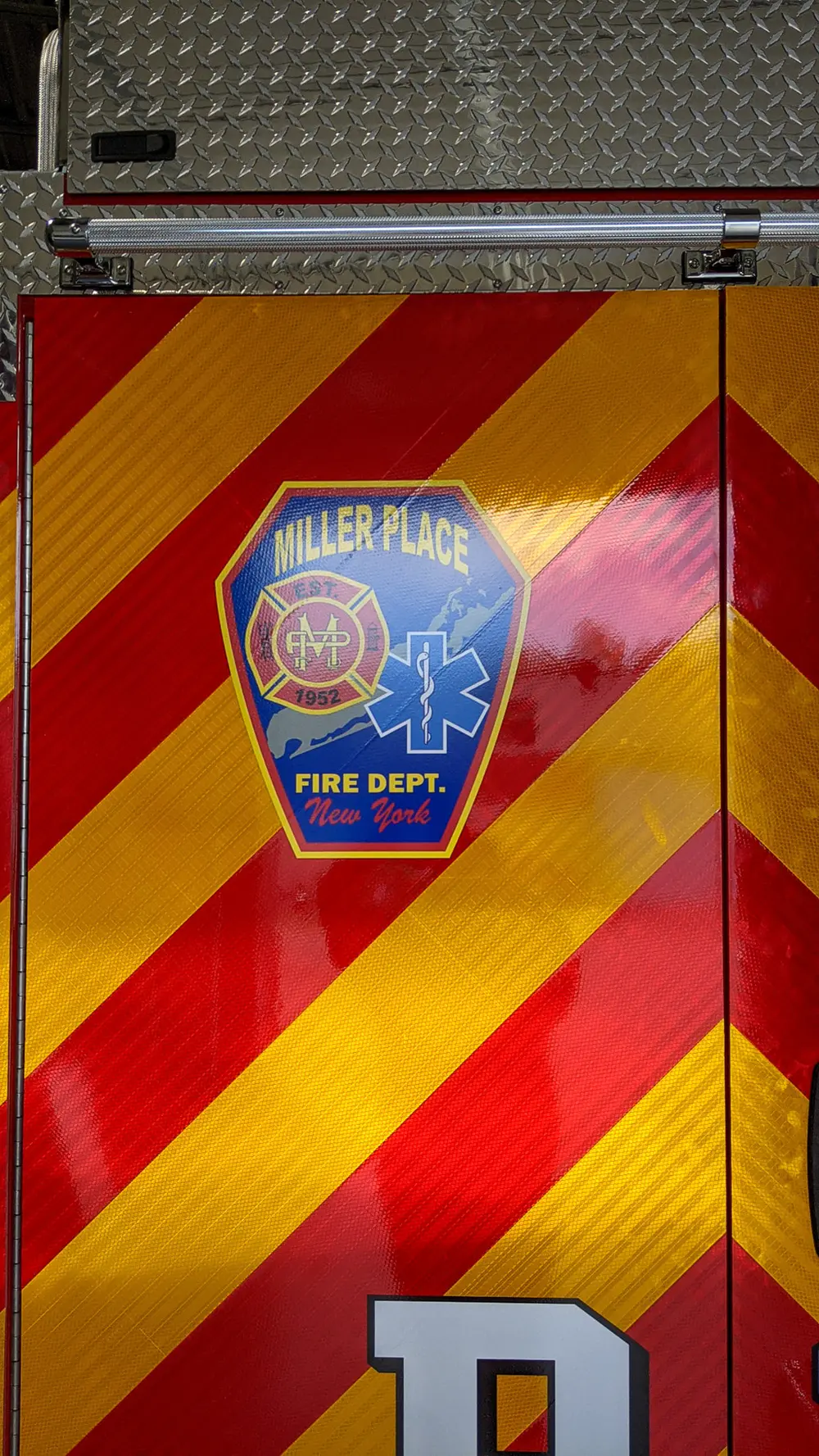 Exterior view of small fire truck showing cab, body compartments, and wheel/tire area.