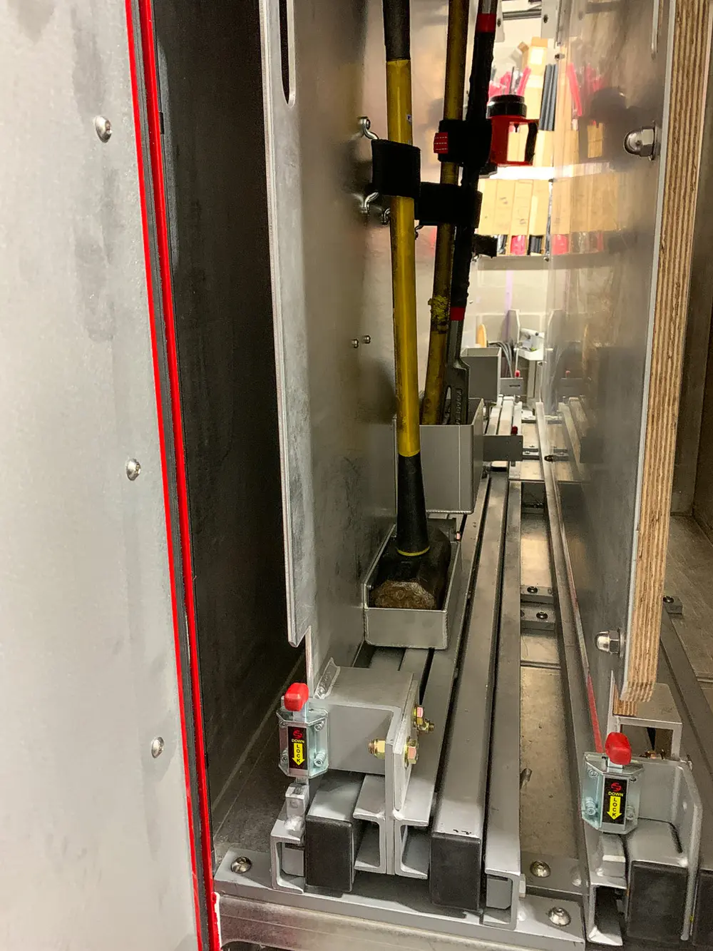 Exterior view of small fire truck showing cab, body compartments, and wheel/tire area.