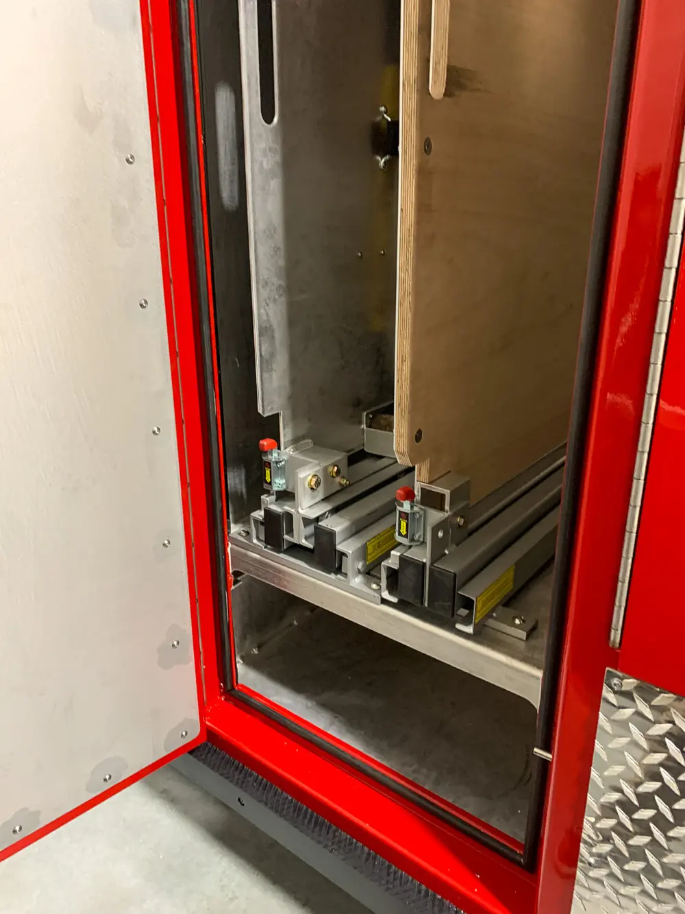 Exterior view of small fire truck showing cab, body compartments, and wheel/tire area.