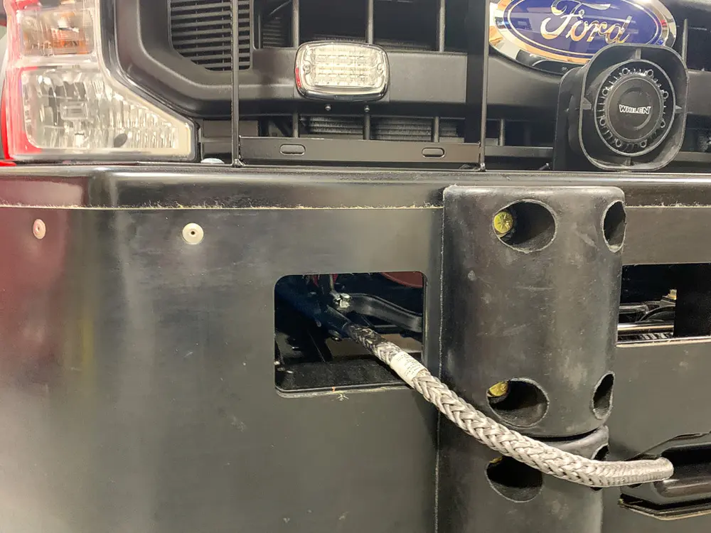 Exterior view of small fire truck showing cab, body compartments, and wheel/tire area.