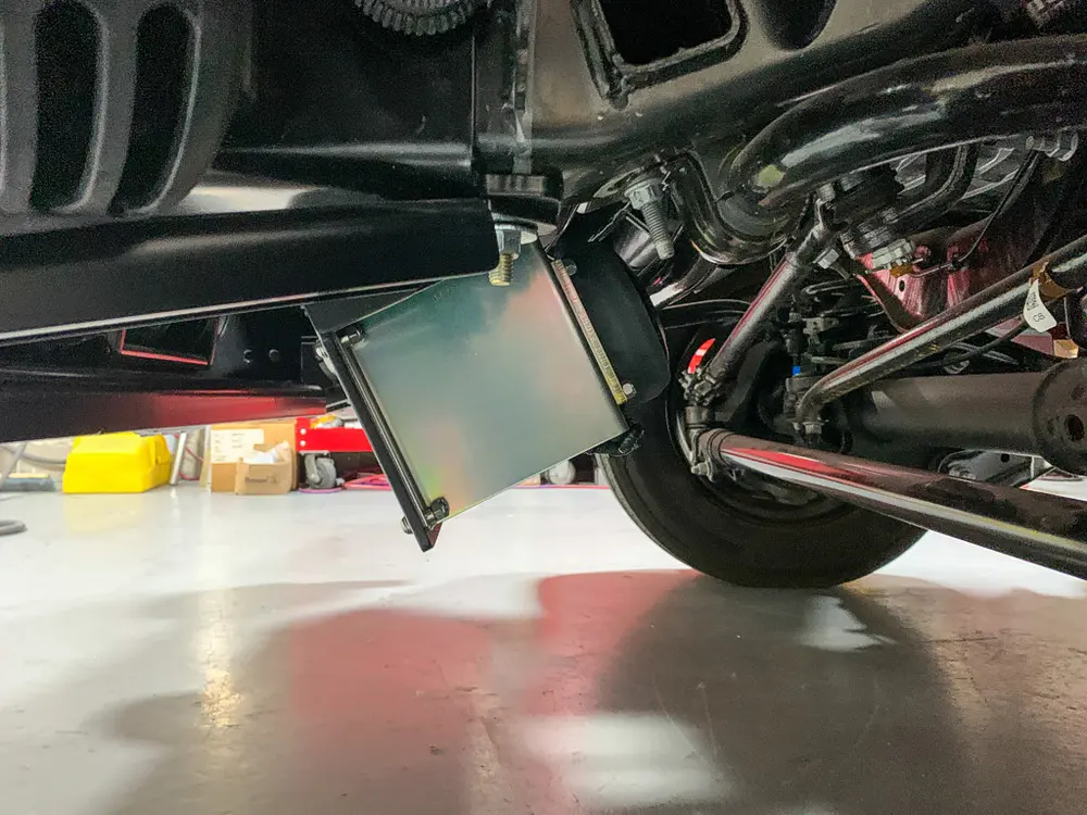 Exterior view of small fire truck showing cab, body compartments, and wheel/tire area.