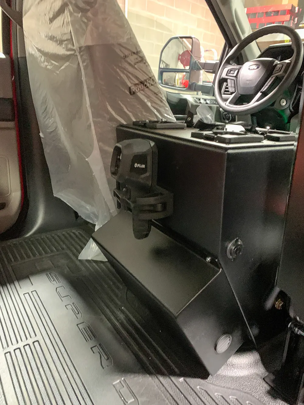 Exterior view of small fire truck showing cab, body compartments, and wheel/tire area.