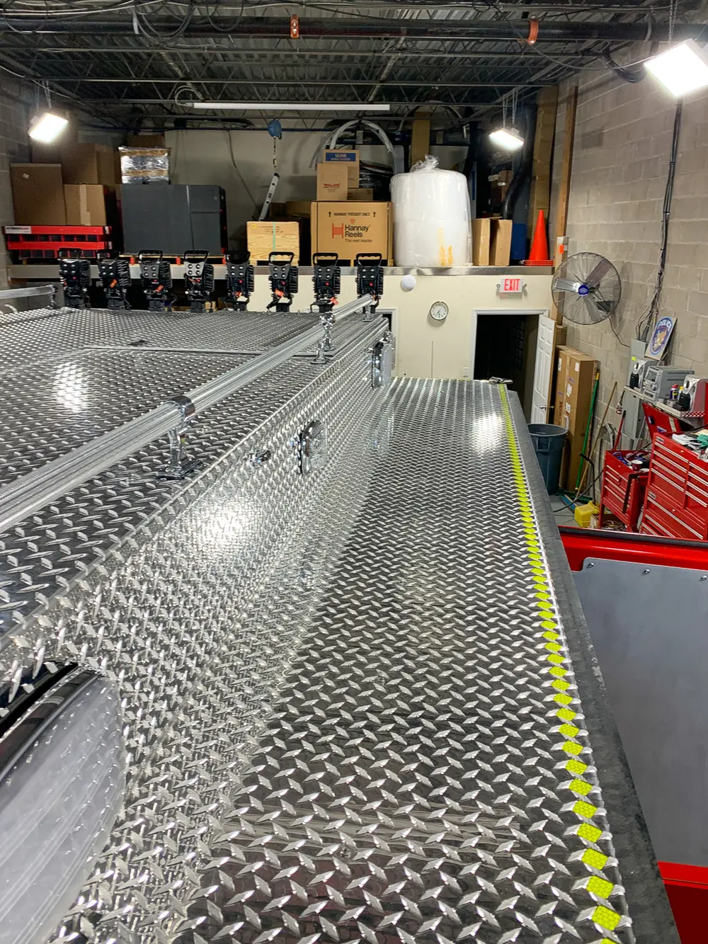 Exterior view of small fire truck showing cab, body compartments, and wheel/tire area.