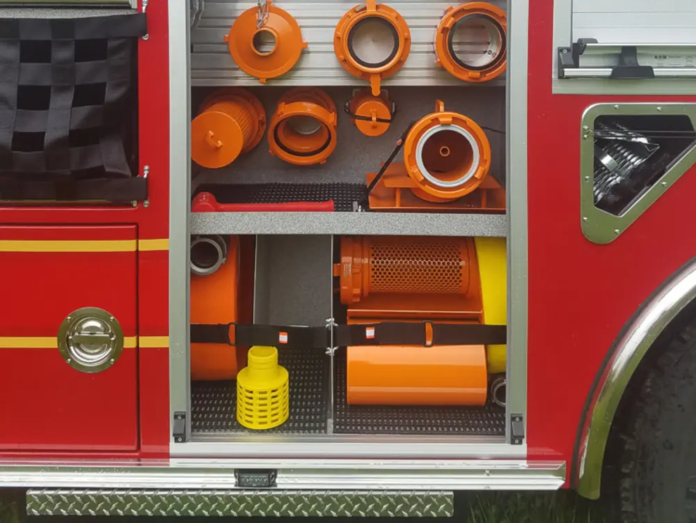 Exterior view of small fire truck showing cab, body compartments, and wheel/tire area.