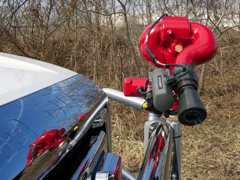 Exterior view of small fire truck showing cab, body compartments, and wheel/tire area.