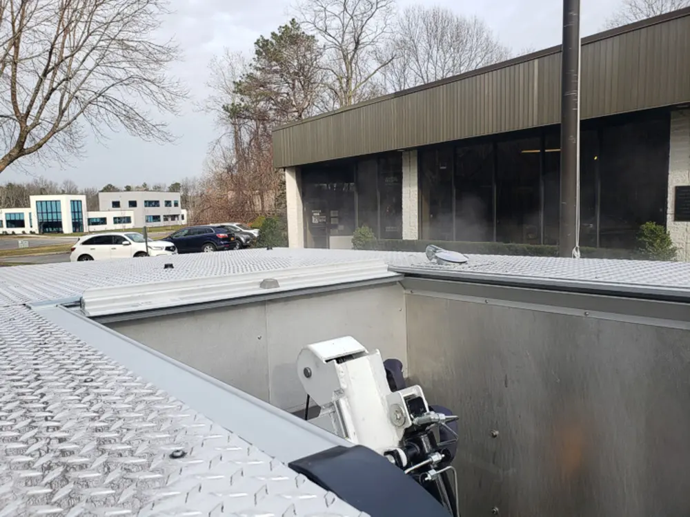 Exterior view of small fire truck showing cab, body compartments, and wheel/tire area.
