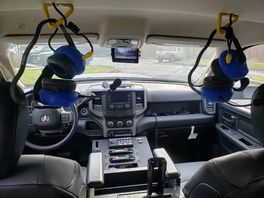 Exterior view of small fire truck showing cab, body compartments, and wheel/tire area.