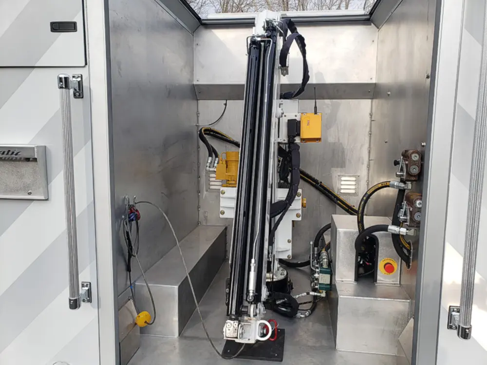 Exterior view of small fire truck showing cab, body compartments, and wheel/tire area.