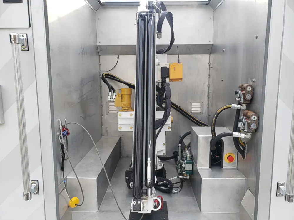 Exterior view of small fire truck showing cab, body compartments, and wheel/tire area.